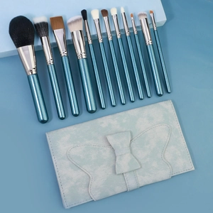 Set di 12 pennelli trucco con manici blu glitterati e custodia con fiocco