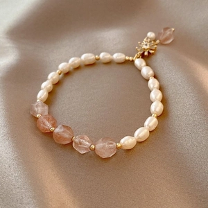 Detail of freshwater pearl bracelet with sunstone beads and sunburst charm