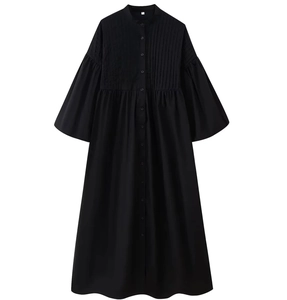 Detail of vertical pleats and button closure on black cotton ramie shirt dress