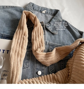 Detail of corduroy tote bag featuring wide adjustable strap and soft ribbed texture