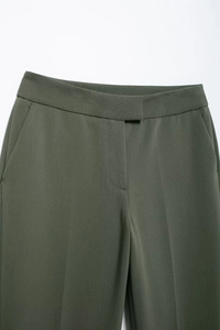 Vue détaillée de la taille du pantalon de costume vert montrant poches et texture du tissu