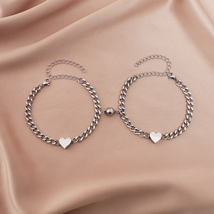 Detail of silver Cuban link bracelets with heart charms and magnetic connection