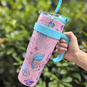 Pink 40oz stainless steel tumbler with ocean cartoon prints and a blue ergonomic handle