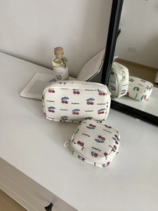 Detailed shot of cherry print canvas cosmetic bags in rectangular and square shapes