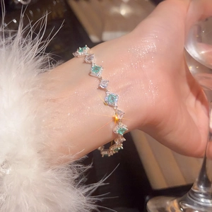 Detail of silver bracelet with green emeralds and cubic zirconia on a wrist