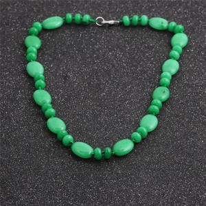 Détail de perles d'œil de tigre vert et d'opale avec fermoir mousqueton sur fond gris