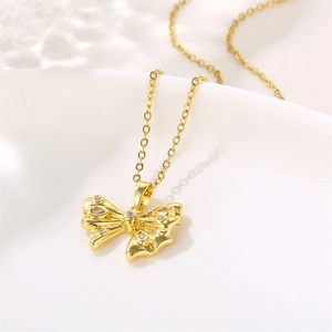Elegant 18K gold bow necklace with zircon accents for women on a white background