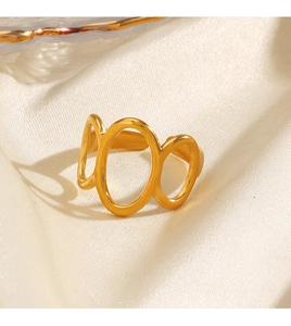 Détail macro d'une bague ovale évidée dorée sur un fond élégant en soie de couleur beige