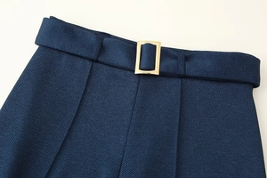 Détails de ce pantalon en sergé bleu foncé à taille haute avec boucle dorée