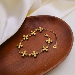Close-up of gold Byzantine style cross links necklace on a dark wooden tray