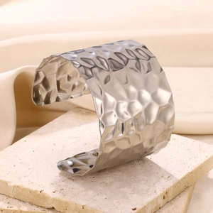 Detailed view of wide open cuff bangle featuring silver hammered texture on stone base