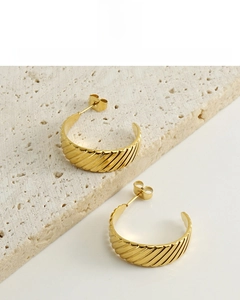 Detail of 18K gold-plated titanium earrings with elegant spiral texture and C-shape