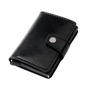 Detail of black leather RFID wallet showing card pop-up trigger and pebbled texture