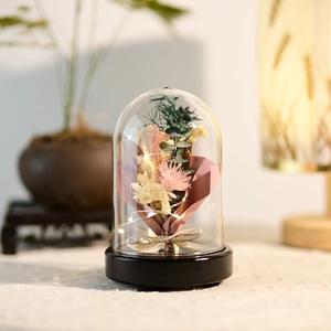 Preserved flower night light in clear dome with LED string lights on a wooden base