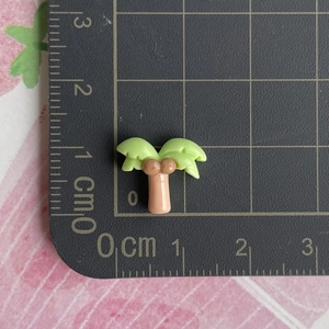 Vue macro d'un mini palmier en résine de 1,5 cm sur une règle graduée pour la taille