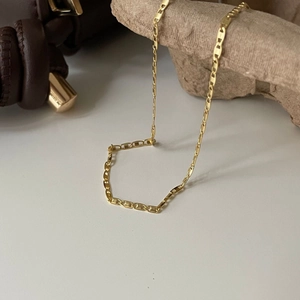 Minimalist 925 sterling silver gold plated chain necklace on decorative stone display