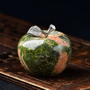Detail of natural crystal apple decor with green and pink texture and diamond-set leaf