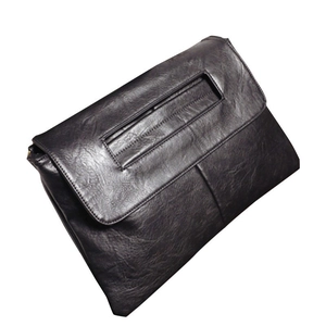 Close-up detail of high-quality black PU leather texture on minimalist envelope clutch