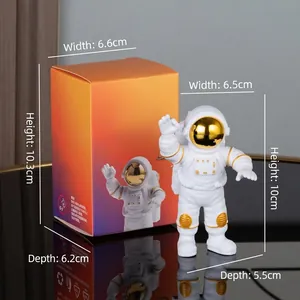 White astronaut figurine with gold visor and orange packaging box detail