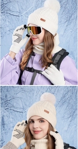 Detail of white knit hat with pompom and touch screen gloves for winter outdoor warmth