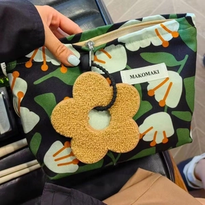 Tropical rainforest floral canvas makeup bag with a yellow plush flower pendant zipper