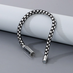 Detail of black braided rope bracelet featuring silver beads and magnetic metal clasp