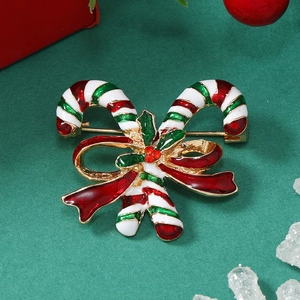 Detailed view of Christmas candy cane brooch with red bow on festive background