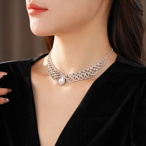 Detailed view of silver lace-pattern teardrop pendant necklace on model collarbone