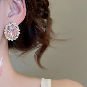 Macro detail of a vintage pink oval gemstone earring with small surrounding diamonds