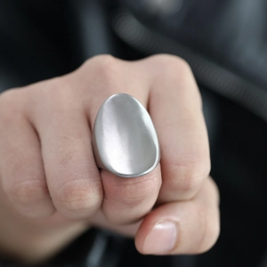 Close-up of a silver oval stainless steel ring with a brushed metal finish for women