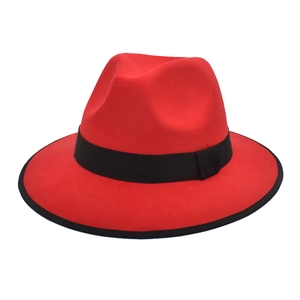 Red wool fedora hat with black ribbon band and trim edge on white background