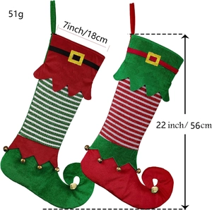 Detail view of elf-style Christmas stockings with sizes and metal bells on white background