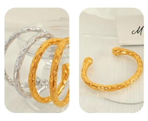 Detailed macro view of gold and silver stainless steel bangles with hammered texture