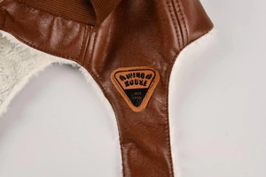 Detailed close-up of brown leather pilot hat showing stitching and warm faux fur lining