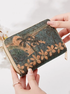 Vintage cork wallet with floral palm print held by hands in a soft floral background