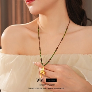 Vintage tiger eye beaded necklace featuring a golden horse pendant worn by a model