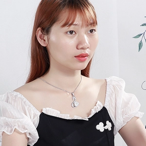 Elegant silver swan necklace with crystal heart pendant on model for stylish look