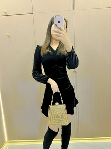 Formal look with gold rhinestone clutch bag paired with a black velvet dress and boots