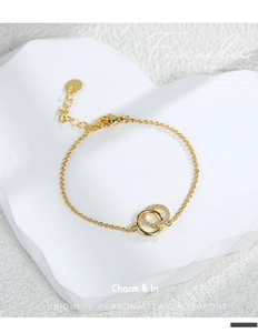 Macro detail of gold plated double circle bracelet with cubic zirconia on white stone