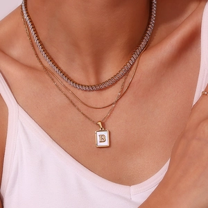 Detailed view of luxury layered necklace set with zircon stones and letter B pendant