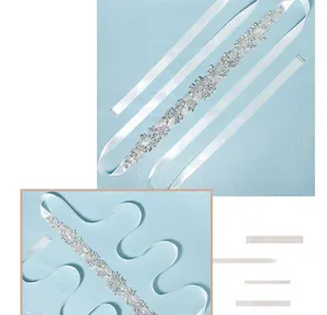 Detailed view of bridal belt featuring rhinestone floral patterns and white satin ribbon
