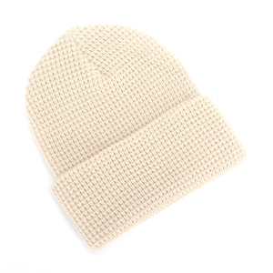 Close-up of cream knit beanie showing the detailed waffle texture and folded cuff edge