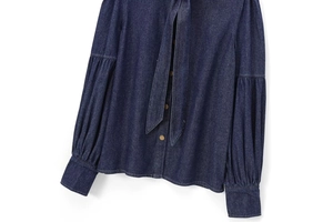 Detail of dark blue denim shirt with bow-tie neck and vintage lantern sleeve texture