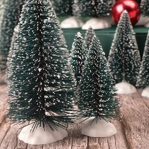Detailed close-up of mini snowy Christmas trees in various sizes for table decor