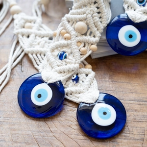 Detail of macramé wall hanging featuring Turkish blue evil eye glass beads and wood beads