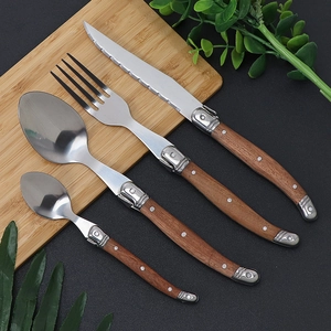 Detailed set of stainless steel cutlery with wood handles on a cutting board