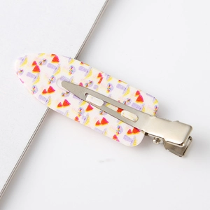 Detailed view of metal hair clips featuring colorful watermelon and mushroom prints