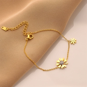 Elegant gold titanium daisy bracelet with sparkling crystals on smooth silk background