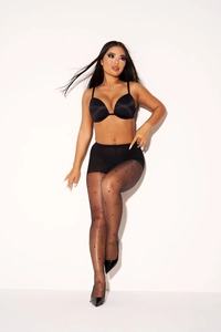 Detail van zwarte transparante panty met stippenpatroon en elegante hoge hakken