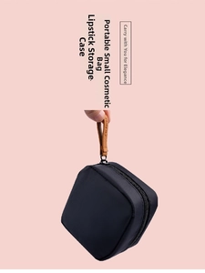 Detail of small portable black cosmetic bag with metal zipper and leather handle strap